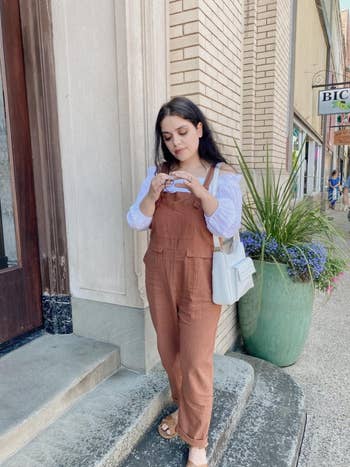 reviewer wearing the overalls in tan