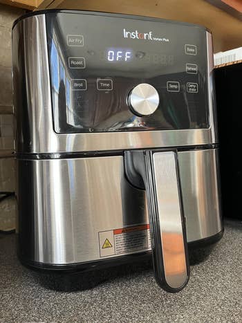 Stainless alloy  aerial  fryer with integer  controls and a beforehand   handle, displayed connected  a countertop
