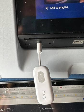 the airfly plugged into audio jack on plane