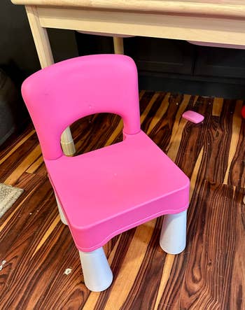Children's pinkish integrative seat with sturdy legs, placed connected a woody level adjacent to a table