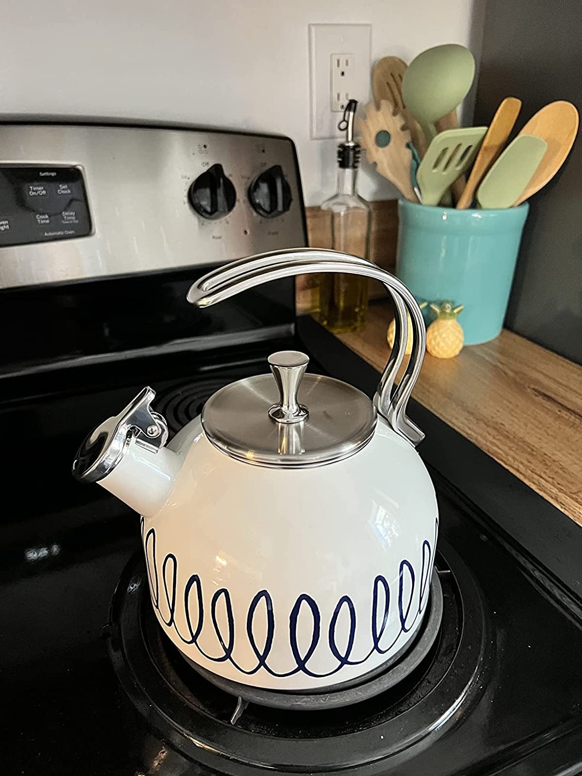 a reviewer's white and navy kettle on the stove