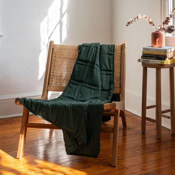 green weight blanket draped over chair