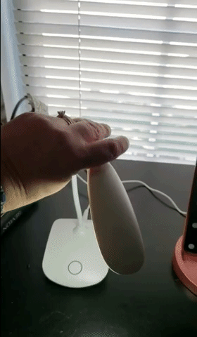 gif of a reviewer's video showing how a white LED desk lamp bends into different positions