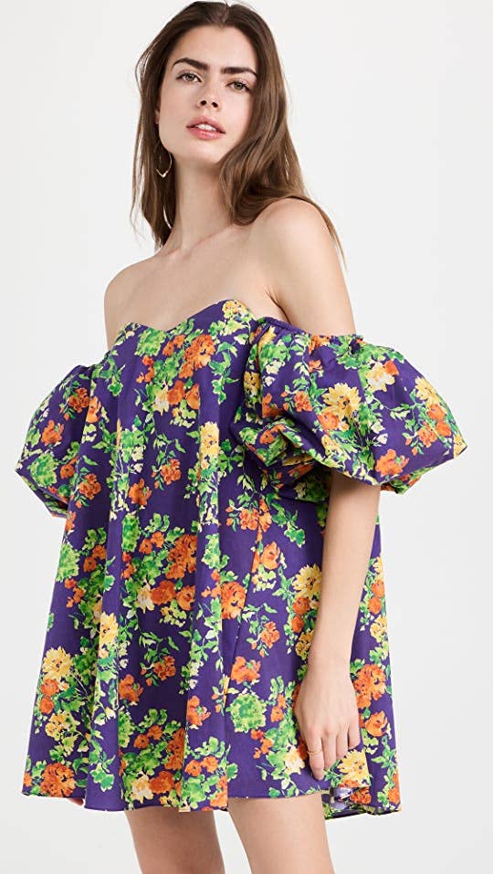 model in large puff sleeve purple tunic dress with orange green and yellow floral print