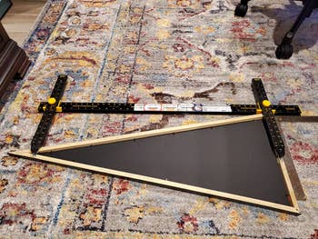 tool being used to align a pennant before hanging it on a wall