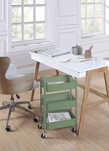 a green three-tier rolling organizer under a desk