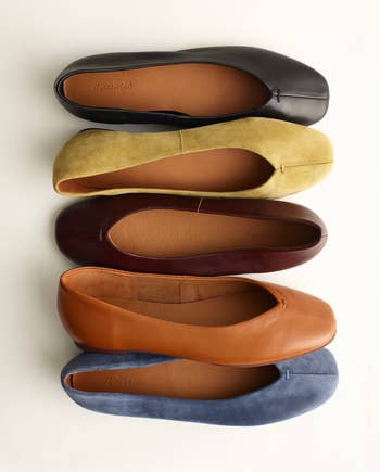 Five pairs of ballet flats successful assorted materials and shades are neatly arranged