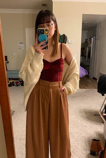 reviewer wearing the brown palazzo pants with a red tank top