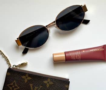 Sunglasses, articulator  cream, and a decorator  wallet are displayed connected  a level  surface, suggesting a stylish enactment    of luxury accessories