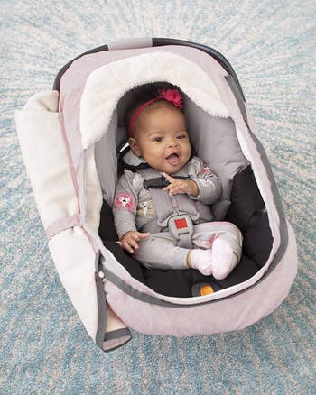 baby inside carseat with cover unzipped 