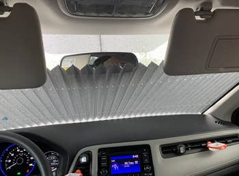 Car interior with a dashboard sunshield, blocking sunlight from coming through the windshield