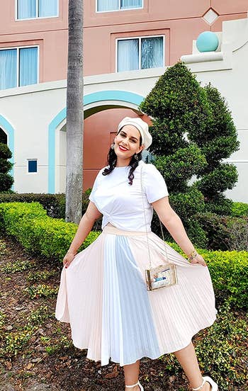 A reviewer wearing the skirt in pink with a blue and white stripe in the middle. Styled with with a simple white tee and heels.