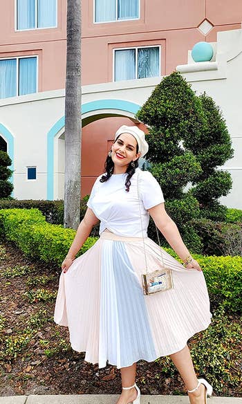 A reviewer wearing the skirt in pink with a blue and white stripe in the middle. Styled with with a simple white tee and heels.