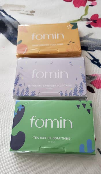 Three packages of Fomin soap thins successful  saccharine  orange, lavender, and beverage  histrion   lipid  scents, displayed connected  a floral background