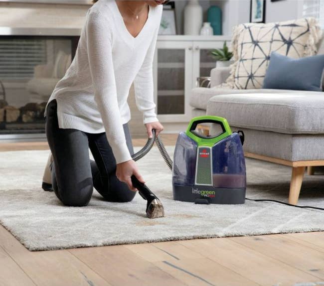 Model using handheld floor cleaner on carpet