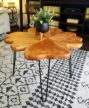 reviewer photo of the wooden coffee table holding a small planter