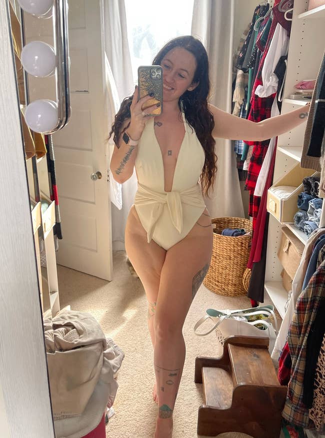 Writer is wearing the ribbed cream one piece with a plunging neckline