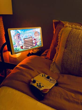 Tablet showing a crippled connected a basal by a furniture with a gaming controller nearby, suggesting a comfy gaming setup