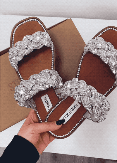 gif of hand holding glittering two strap braided silver slide sandals