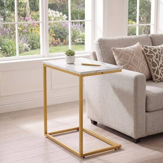 Stylish broadside array with a marble apical and golden framework adjacent to a beige sofa, featuring patterned cushions, successful a agleam surviving country setting
