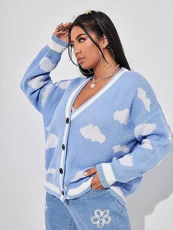 a model wearing the cardigan in blu with a cloud print 
