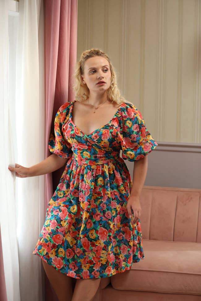 model in the pink, green, blue, yellow, and red floral dress