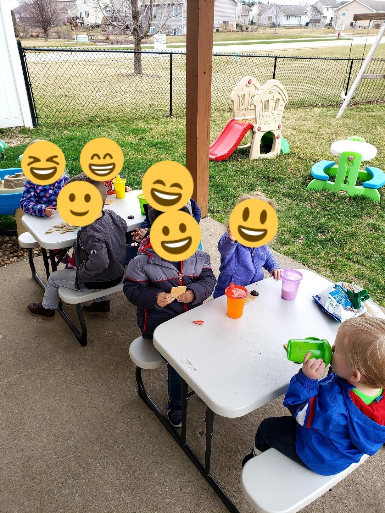 a review photo of kids sitting at the picnic tables outdoors
