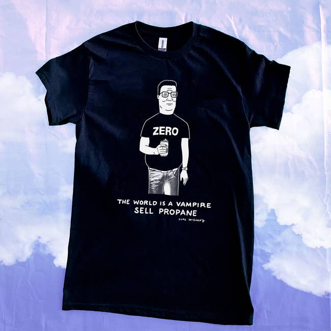 Black t-shirt with a caricature of Hank Hill holding a cup and the text 