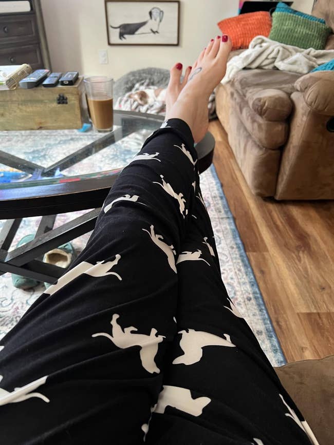 Person relaxing with feet up   connected  a java  table, wearing pajama pants with feline  patterns, successful  a cozy surviving  country   setting