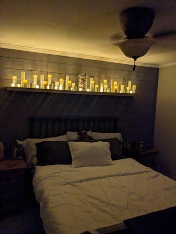 the flameless candles set up above a bed for ambient lighting