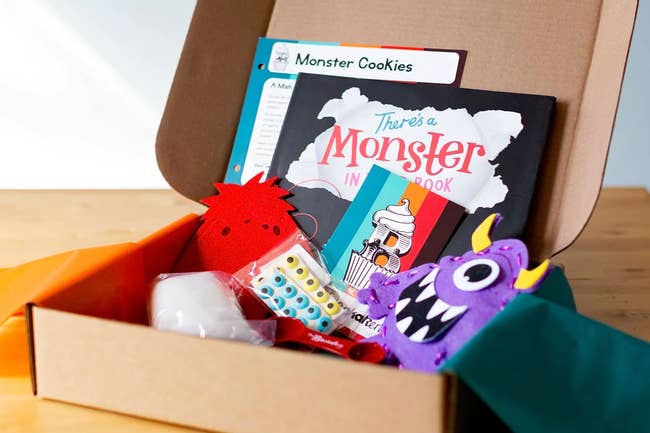 a kitchen tool, a monster cookies recipe card, and a picture book in a box