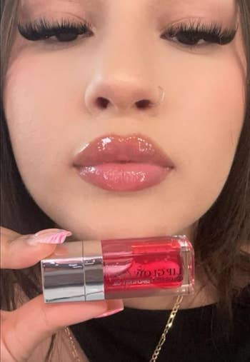 Social media trends Viral content Trending hashtags Social media updates Trending memes and videos A close-up of a reviewer with glossy lips holding a tube of gloss 