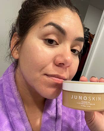 Reviewer holding a jar of cleansing balm 