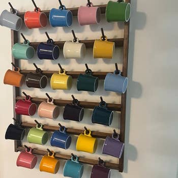 a set of colorful mugs on the dark wood organizer