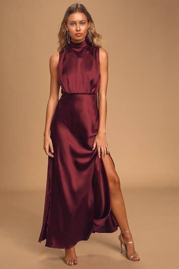 model in burgundy sleeveless dress with side slit