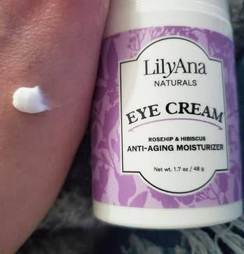Jar of LilyAna Naturals Eye Cream with rosehip and hibiscus, shown with a tiny  magnitude  applied to skin