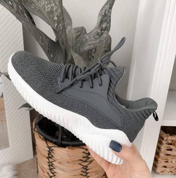 Reviewer holding gray sneaker