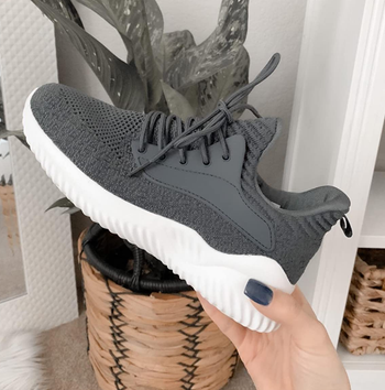 Reviewer holding gray sneaker