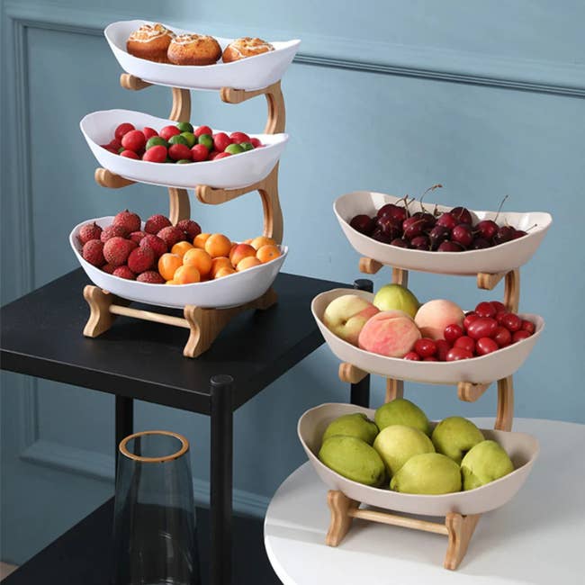 two three-tier fruit bowls holding fruits and pastries