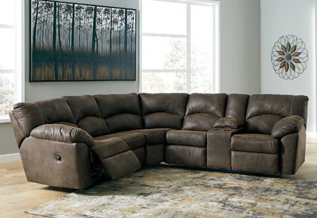lifestyle image of brown faux leather reclining sectional sofa