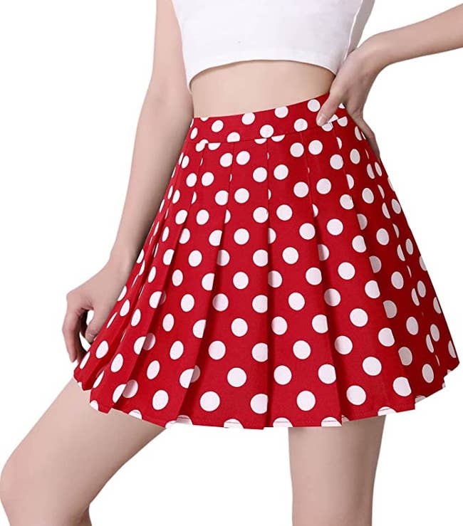a model in a pleated red skirt with white polka dots on it