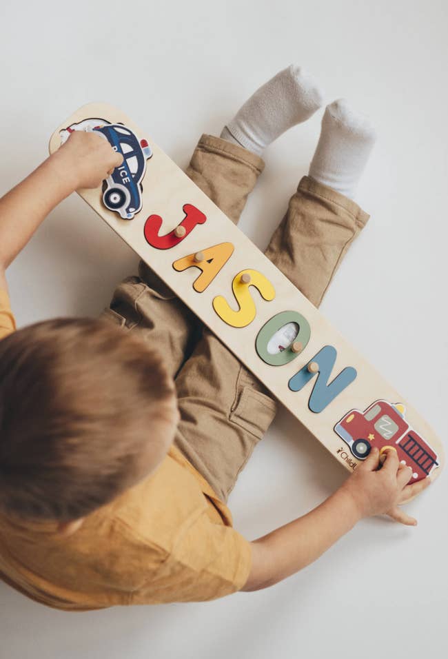 A child holding the puzzle on their lap