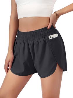 a model wearing the black shorts with a phone in the pocket
