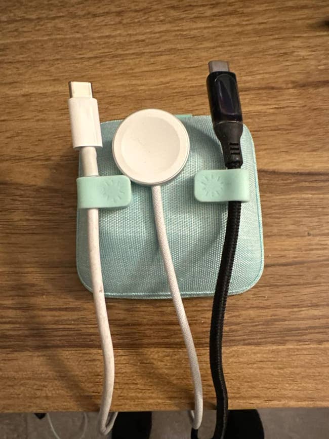 Charging cables and a wireless charger are neatly organized utilizing 2  cablegram  clips connected  a small, quadrate  lawsuit  connected  a woody  surface