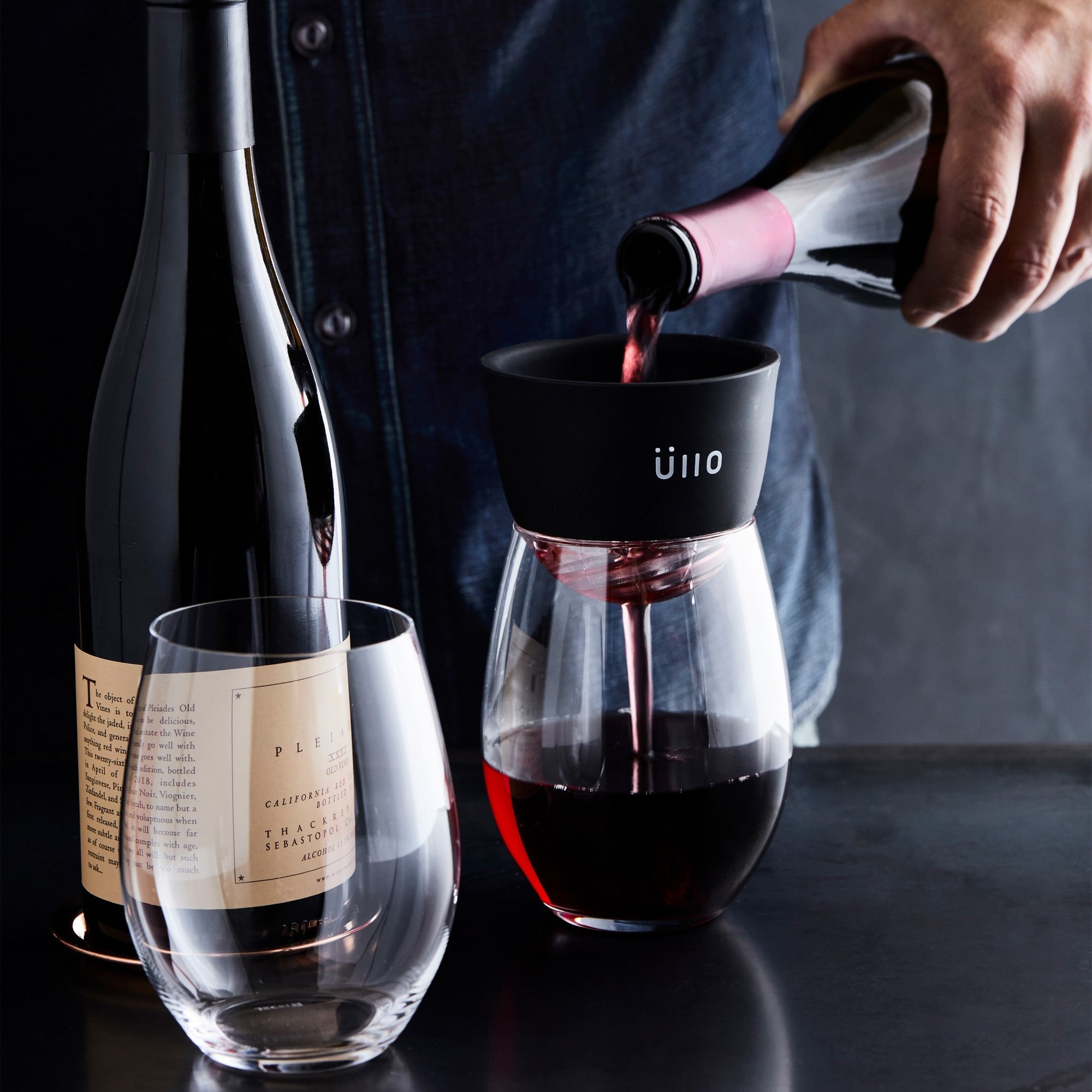 Model pouring red wine through Ullo purifier into wine glasses