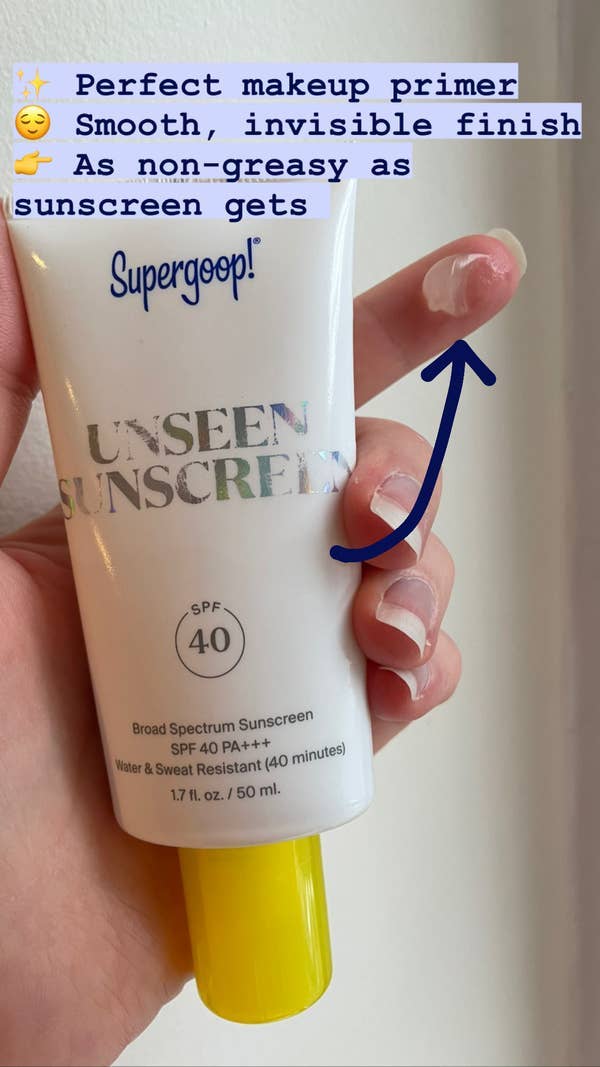 BuzzFeed Shopping editor holding the Supergood Unseen Sunscreen with a swatch on their finger labeled 