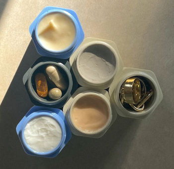 overhead shot of six open containers holding things like pills, skincare products, and jewelry