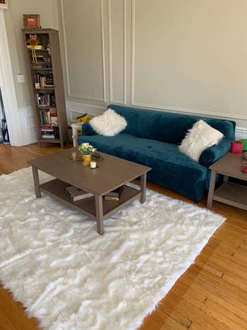 the white faux fur rug down on a living room floor