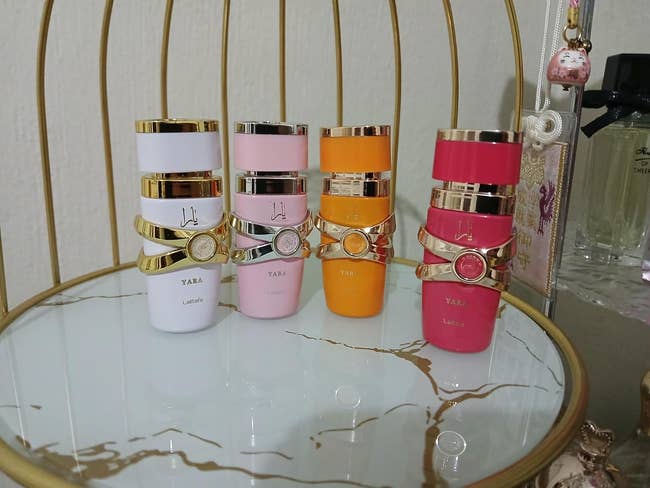 Display of luxurious perfume bottles with elegant golden accents connected a marble stand, suitable for a buying feature
