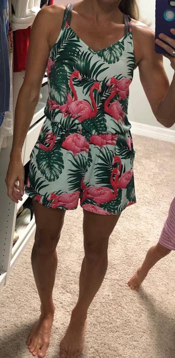 reviewer wearing the romper in mint and pink with a flamingo and leaf print